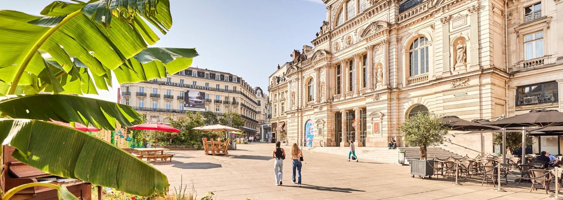 Two young women walking on the Place du Ralliement 