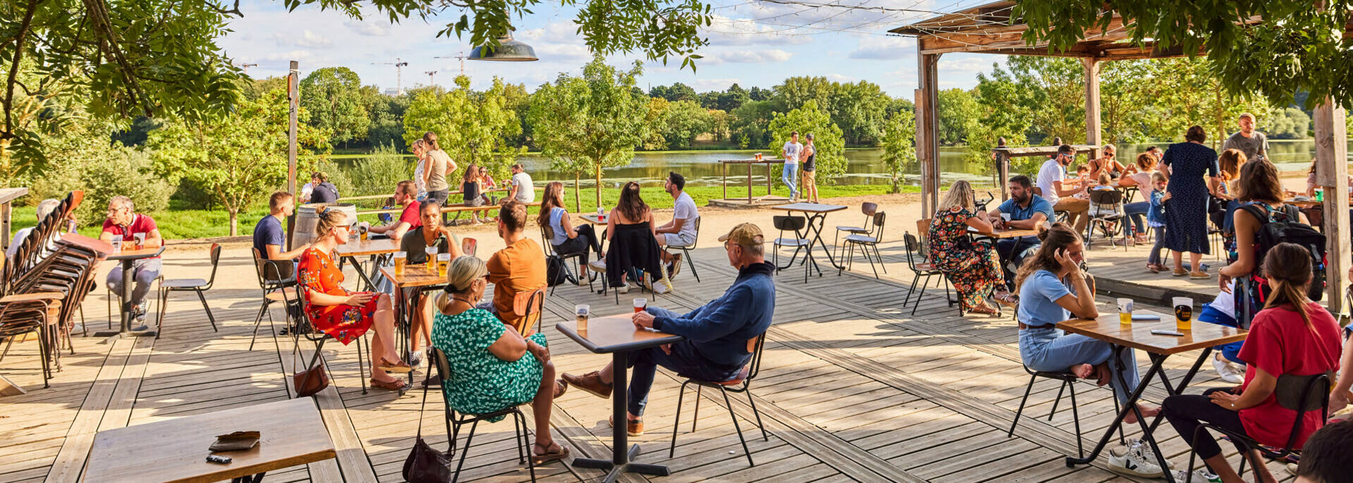 Wide shot of the well-frequented terrace of the Riverside caféin summer on the banks of the Maine