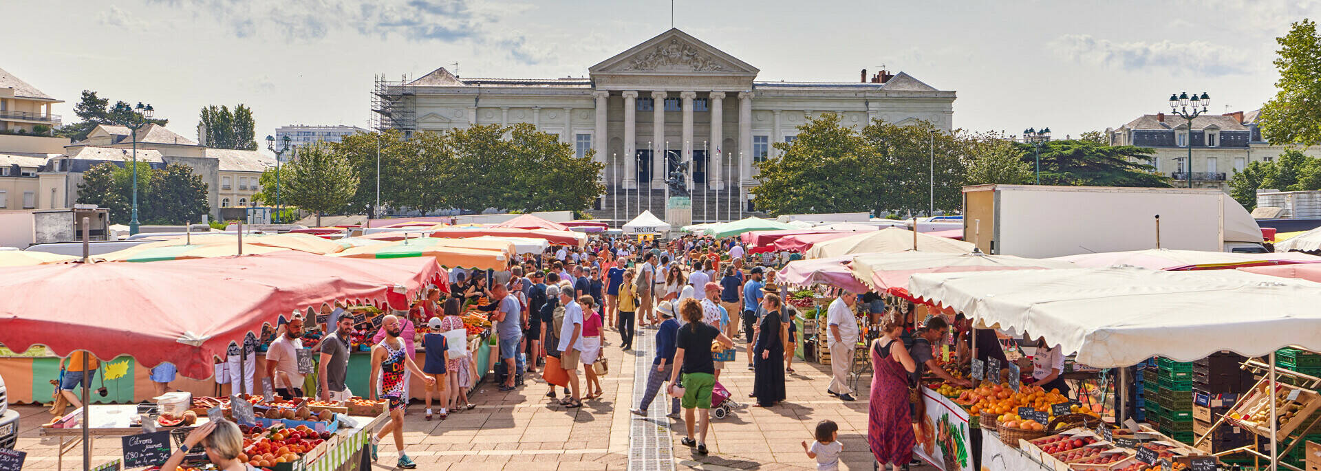 Gran plano del mercado y sus puestos, plaza Leclerc, con el palacio de justicia al fondo.