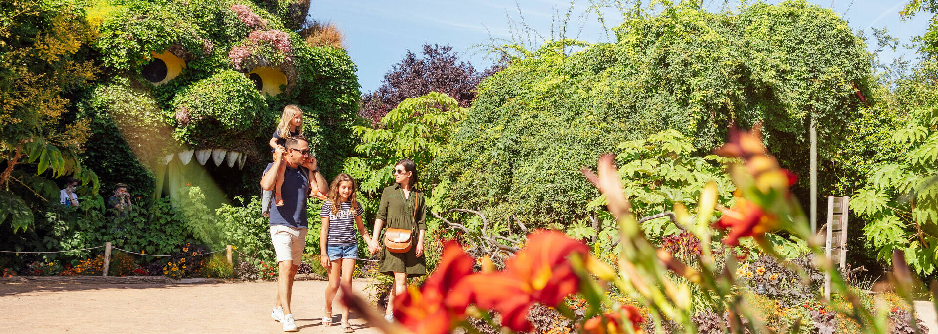 Un couple et leurs deux filles marchant dans les allées du parc à thème végétal