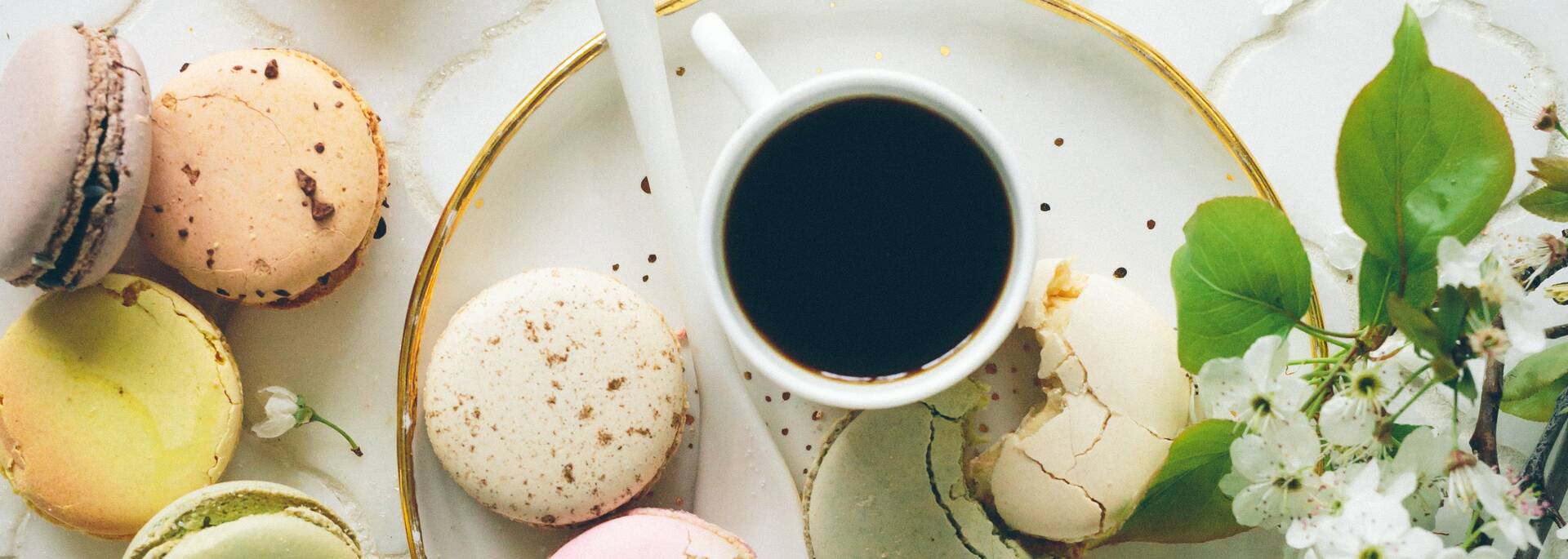 Tasse de café entourée de macarons