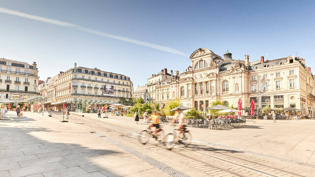 Two cyclists passing Place du Ralliement in front of the Grand Théâtre