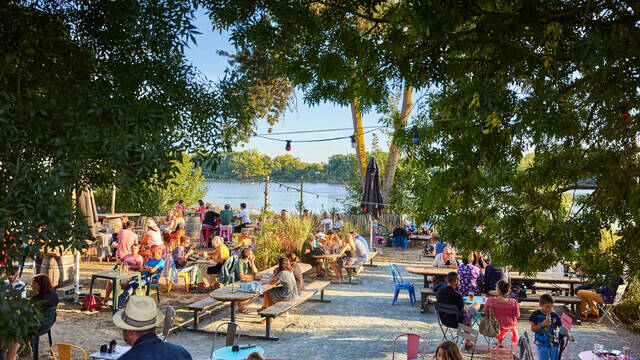 Ambiance estivale en terrasse à la guinguette de Port Thibault, de nombreuses personnes profitent de la fin de soirée au soleil face à la Loire
