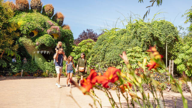 Un couple et leurs deux filles marchant dans les allées du parc à thème végétal