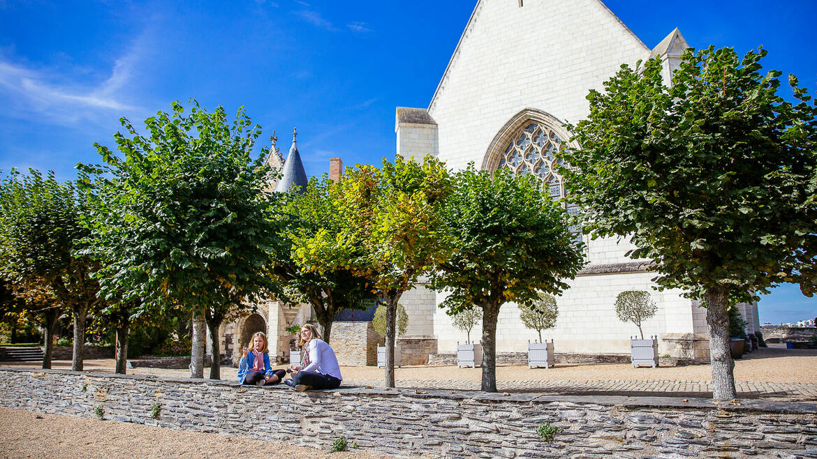 A mother and daughter sitting on a low wall in the castle grounds