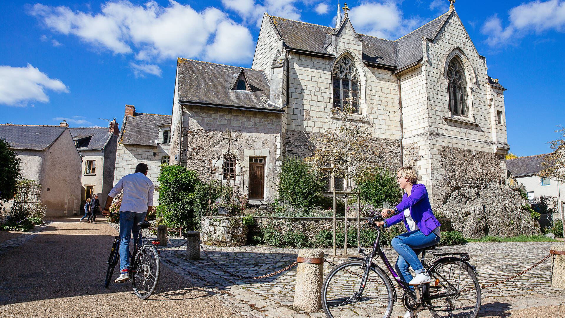 Cyclistes passant au bord de l'église de Béhuard