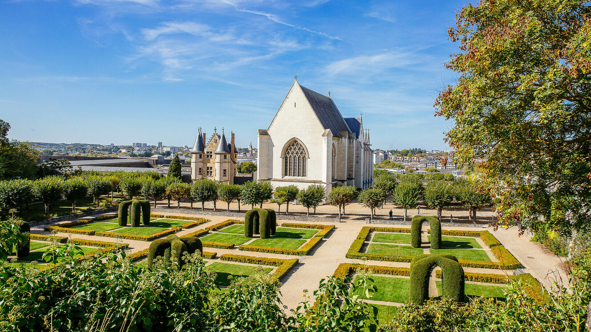 Wide shot of the gatehouse and chapel with the gardens in the foreground