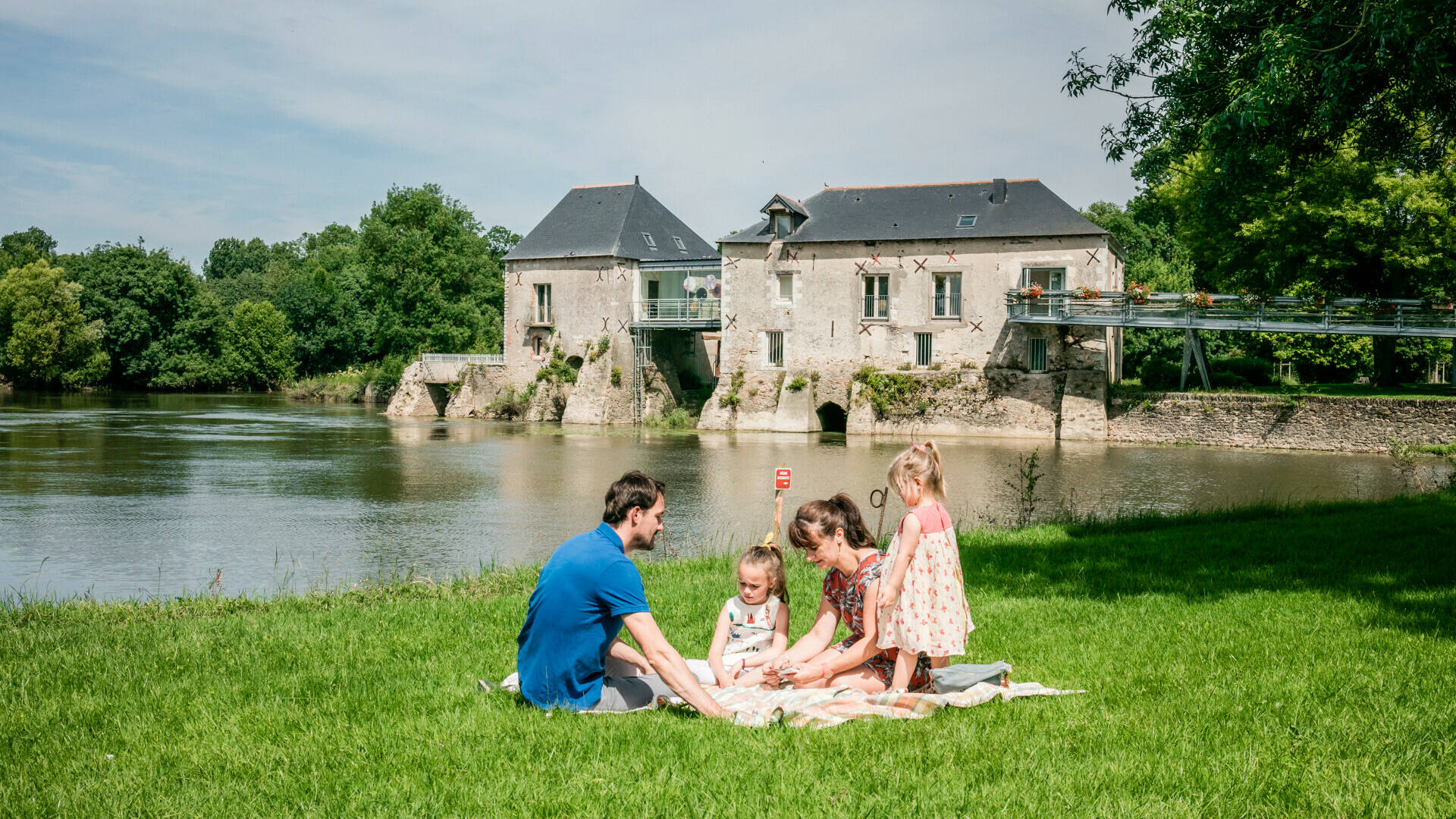 Family picnicking on the lawn in front of the mill