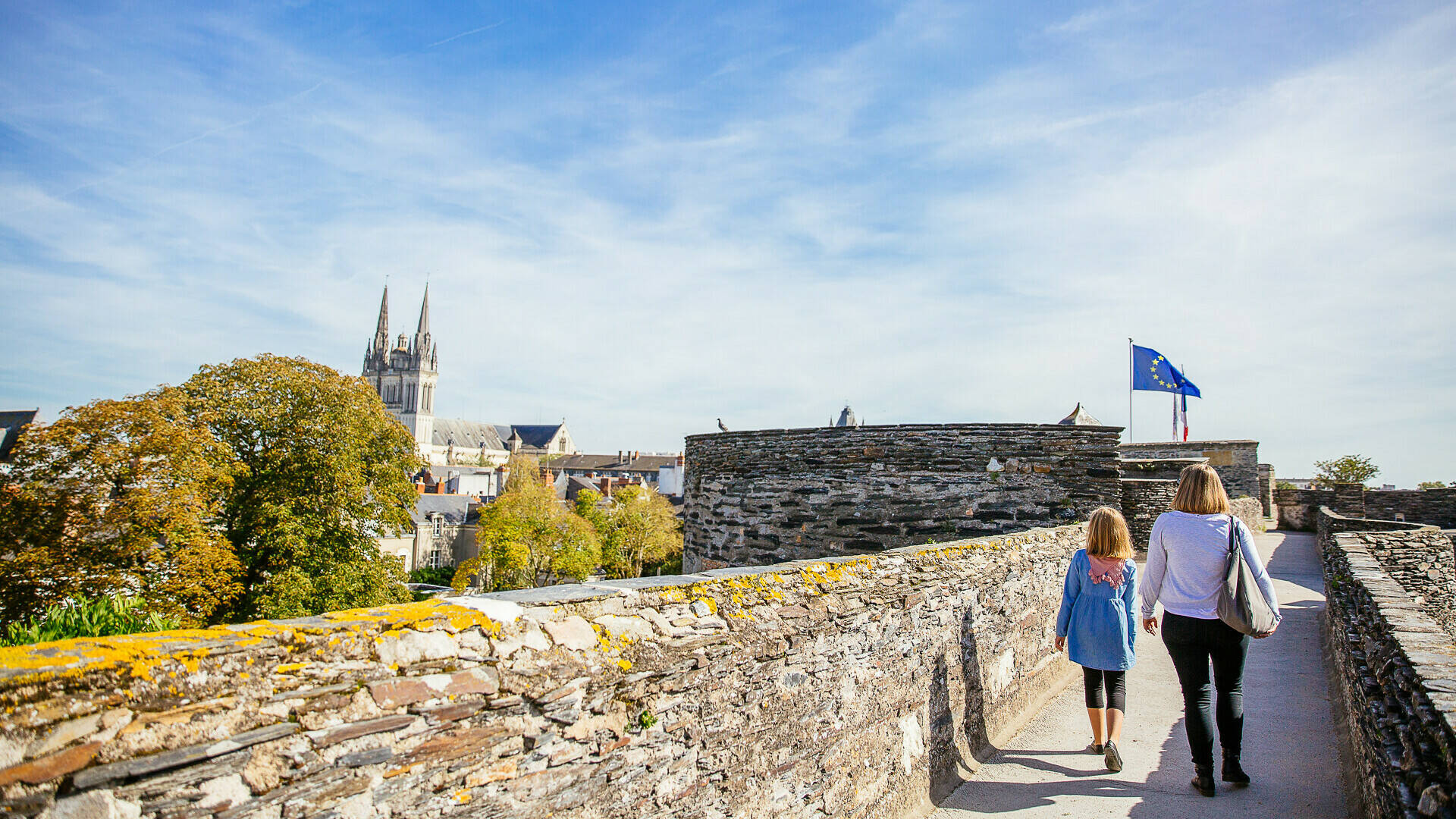 A mother and daughter strolling along the walkway