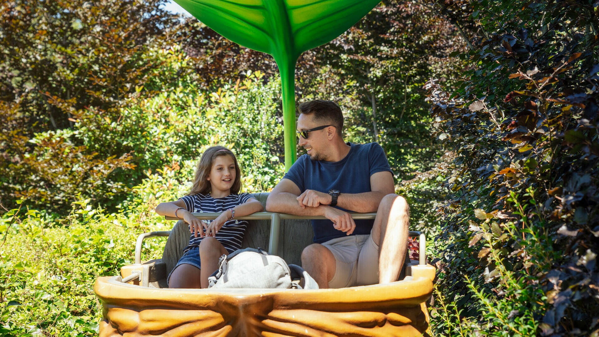 Père et sa fille dans une attraction en forme de coquille de noix