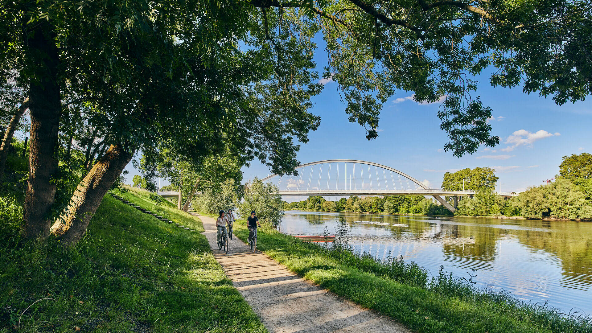 3 friends ride on bike on the towpath on the banks of the Maine 