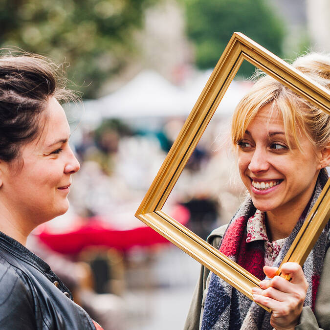 2 women having fun with an empty frame