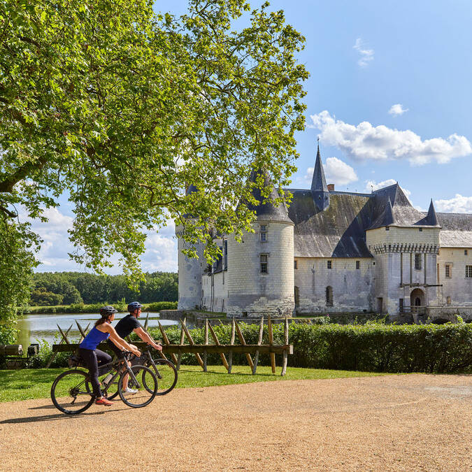 Gravel cyclists in front of the Plessis-Bourré castle