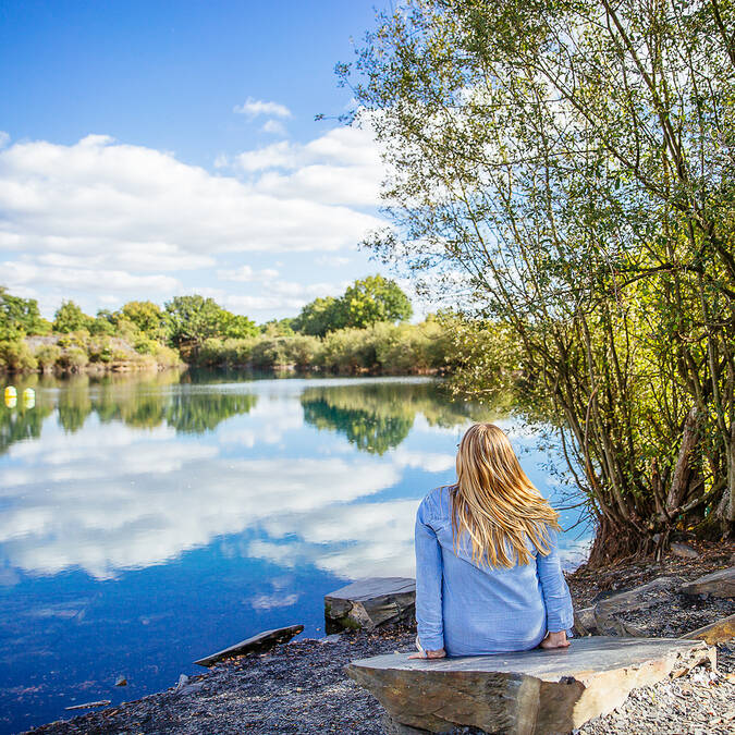 Young woman at the edge of a pond in the Ardoisières park in Trélazé